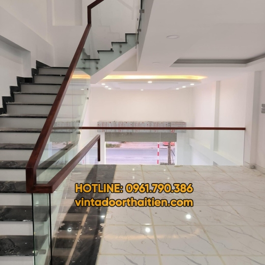 Cầu thang kính cường lực tay vịn gỗ